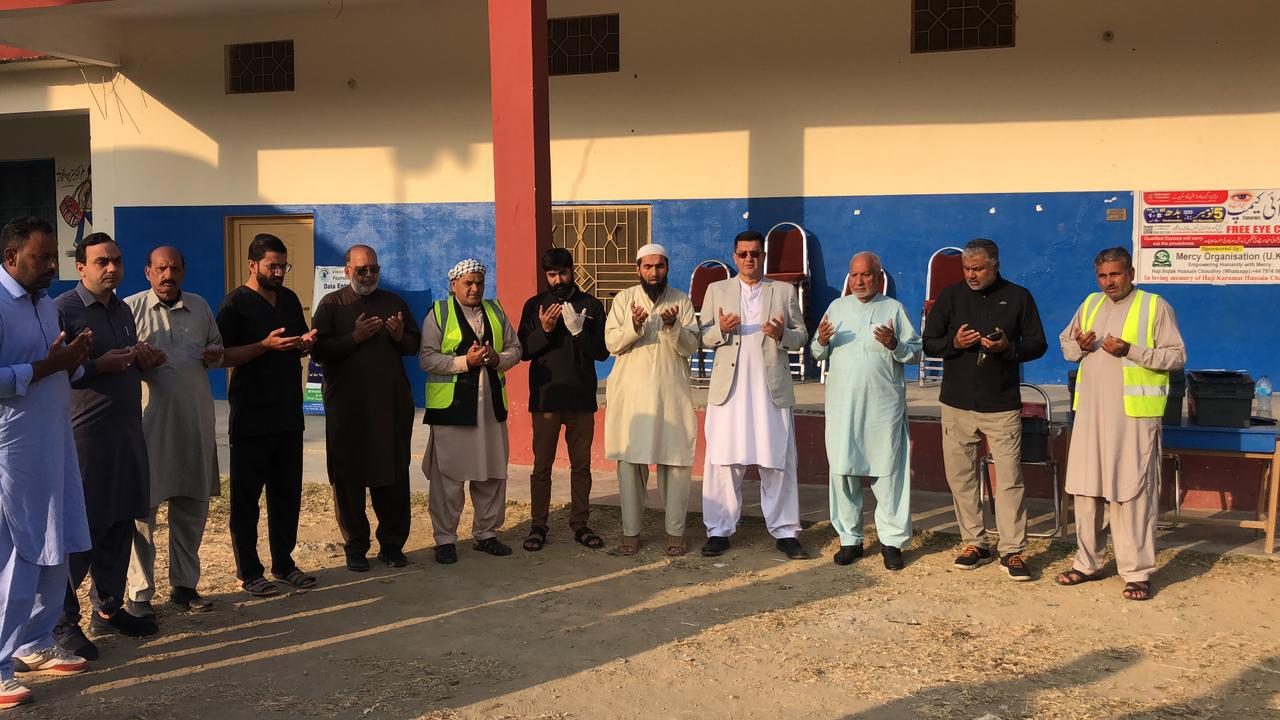 Volunteers and organisers praying before an eye camp