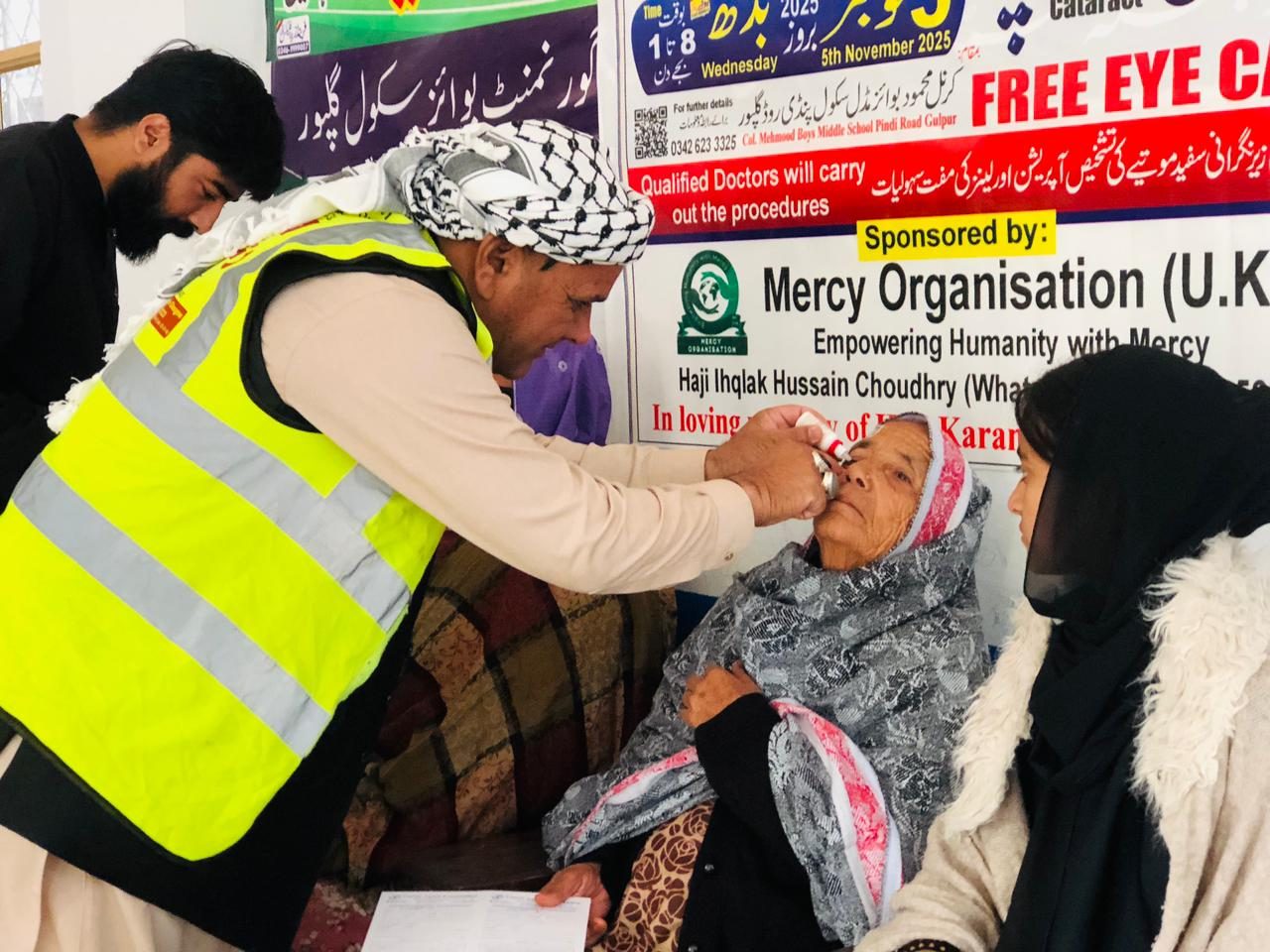 A volunteer giving a patient eye drops